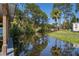 Scenic waterfront view with a dock and lush greenery, reflecting in the calm water at 12009 Eagle Point Ct, Leesburg, FL 34788