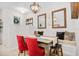 Elegant dining area featuring stylish red chairs, a modern chandelier, and eye-catching wall decor with tiled floors at 1349 Mill Stream Ln, Winter Springs, FL 32708