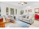 Bright living room featuring a comfortable sofa, patterned armchair, and large windows for natural light at 1349 Mill Stream Ln, Winter Springs, FL 32708