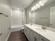 Bright bathroom features a double sink vanity, a tub with a shower, and modern fixtures at 2564 Hawks Overlook Pl, Oviedo, FL 32765