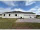 Exterior side view of a three car garage home, green grass and blue sky at 2564 Hawks Overlook Pl, Oviedo, FL 32765