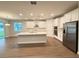 Modern kitchen boasts stainless steel appliances, a center island, and sleek white cabinetry at 2564 Hawks Overlook Pl, Oviedo, FL 32765