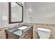A bathroom showcasing a granite countertop vanity and a framed mirror surrounded by light-colored tiles at 1322 Susannah Blvd, Orlando, FL 32803