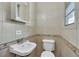 Compact bathroom featuring cream-colored tiles, a classic vanity, and a toilet in a traditional style at 1322 Susannah Blvd, Orlando, FL 32803