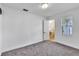 An empty bedroom with grey carpet, white walls, and an open door to a tiled bathroom at 1322 Susannah Blvd, Orlando, FL 32803