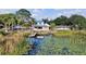 Beautiful waterfront home featuring a dock, a blue roof, and a charming outdoor patio, perfect for lakeside living at 1322 Susannah Blvd, Orlando, FL 32803