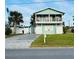 Two-story teal home with a balcony, driveway, and grassy yard at 3949 S Peninsula Dr, Port Orange, FL 32127