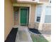 Inviting entrance with a decorative green door and fresh landscaping at 2618 Coventry Ln, Ocoee, FL 34761