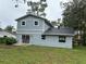 A view of the rear exterior of a home showing light blue siding and sliding glass doors at 3505 Pine Ridge Ct, Orlando, FL 32808