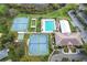 Aerial view of community amenities, including tennis courts, pool, and clubhouse at 5825 Princess Caroline Pl, Leesburg, FL 34748