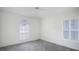 Bright bedroom featuring a large window, shutters, and neutral carpet at 5825 Princess Caroline Pl, Leesburg, FL 34748