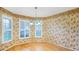 Cozy dining room with hardwood floors, floral wallpaper, and traditional light fixture at 5825 Princess Caroline Pl, Leesburg, FL 34748