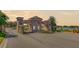 Elegant community entrance gate with stone pillars, decorative railings, and beautifully landscaped surroundings at 5825 Princess Caroline Pl, Leesburg, FL 34748