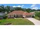 Charming single-story home features a lush lawn, manicured landscaping, and a screened two-car garage at 5825 Princess Caroline Pl, Leesburg, FL 34748