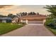 House exterior showcasing a two-car garage and lush green lawn at 5825 Princess Caroline Pl, Leesburg, FL 34748