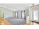 Open-concept living room with hardwood floors, vaulted ceilings, and large windows at 5825 Princess Caroline Pl, Leesburg, FL 34748