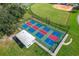 Aerial view of a well-maintained pickleball court with vibrant colors and surrounding green space at 5825 Princess Caroline Pl, Leesburg, FL 34748