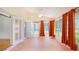 Bright sunroom with large windows, orange curtains, a ceiling fan, and access to the outdoors at 5825 Princess Caroline Pl, Leesburg, FL 34748