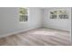 Bright bedroom with light grey walls, wood-look flooring, and large windows at 1111 N Hart Blvd, Orlando, FL 32818