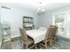 Charming dining room with large window, stylish chairs and a patterned rug at 202 Sweetwater Club Blvd, Longwood, FL 32779