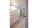 Bathroom featuring double sinks, a large mirror, a window, and a glass-enclosed shower at 4423 Real Ct, Orlando, FL 32808