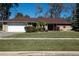 Tan house with red roof, white garage door, and landscaped lawn at 4423 Real Ct, Orlando, FL 32808