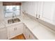 Bright kitchen featuring white cabinets, quartz countertops, and a stainless steel sink at 4423 Real Ct, Orlando, FL 32808