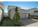 Attached garage with light beige exterior and a brick paver driveway at 5554 Stockade Blvd, Saint Cloud, FL 34771