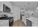 Modern kitchen with white cabinets, island, and stainless steel appliances at 5554 Stockade Blvd, Saint Cloud, FL 34771