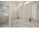 Well-lit bathroom showcasing a double vanity with white cabinets, stone counters, rectangular mirrors, and a walk-in shower at 1020 W Princeton St, Orlando, FL 32804