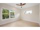 This bedroom has wood floors, a modern ceiling fan, neutral walls, and several windows that provide natural light at 1020 W Princeton St, Orlando, FL 32804