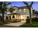 Charming two-story home with landscaped yard, portico, and driveway at dusk at 1020 W Princeton St, Orlando, FL 32804