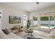 Bright living room with comfortable seating, a mounted TV, and sliding glass doors leading to a private pool area at 1020 W Princeton St, Orlando, FL 32804