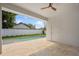 Spacious covered patio with travertine pavers and a ceiling fan, overlooking the pool and fenced backyard at 1020 W Princeton St, Orlando, FL 32804