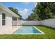 Backyard pool with travertine patio and a white vinyl fence provides privacy within a landscaped yard at 1020 W Princeton St, Orlando, FL 32804