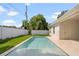 Backyard pool with travertine patio and white vinyl fence surrounding the well-manicured backyard of the home at 1020 W Princeton St, Orlando, FL 32804