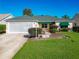 Charming single-story home boasting a green roof, green awnings, lush lawn, and well-maintained landscaping at 3049 Glenwood Pl, The Villages, FL 32162