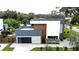 An aerial view of a contemporary home featuring a stylish garage, complemented by a well-maintained lawn and green landscape at 2522 Lafayette Ave, Winter Park, FL 32789