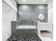 Luxurious bathroom with marble walls, a soaking tub, glass-enclosed shower, and double vanities for a spa-like retreat at 2522 Lafayette Ave, Winter Park, FL 32789