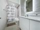 Clean bathroom featuring a shower/tub combo with decorative curtain, a lighted mirror, and modern vanity at 2522 Lafayette Ave, Winter Park, FL 32789