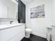Sleek half bathroom with modern fixtures, a floating vanity, and stylish black tile accent wall at 2522 Lafayette Ave, Winter Park, FL 32789