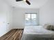 Neutral-toned bedroom with stylish wood floors, a ceiling fan, and a large window offering ample natural light at 2522 Lafayette Ave, Winter Park, FL 32789