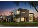 Stunning modern home with a sleek dark and white exterior, complemented by a well-manicured lawn at twilight at 2522 Lafayette Ave, Winter Park, FL 32789
