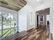 Hallway with wood floors that leads to a bedroom and a modern staircase featuring large windows and natural light at 2522 Lafayette Ave, Winter Park, FL 32789