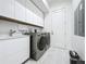 Clean laundry room featuring white cabinets, front load washer and dryer, and modern countertops at 2522 Lafayette Ave, Winter Park, FL 32789