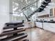 Bright and spacious living area featuring a floating staircase, hardwood floors, and bar area with stainless steel appliances at 2522 Lafayette Ave, Winter Park, FL 32789