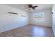 Well-lit bedroom featuring wood floors, neutral walls, a large window, and modern ceiling fan at 176 Blackstone Creek Rd, Groveland, FL 34736
