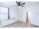 A bedroom with hardwood floors, a window with blinds and curtains, and neutral-colored walls at 176 Blackstone Creek Rd, Groveland, FL 34736
