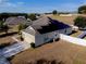 Aerial view of a modern home featuring a well-maintained lawn, concrete driveway, and fenced yard at 176 Blackstone Creek Rd, Groveland, FL 34736