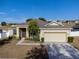 Charming single-story home with a well-manicured front yard, concrete walkway, and a two-car garage at 176 Blackstone Creek Rd, Groveland, FL 34736